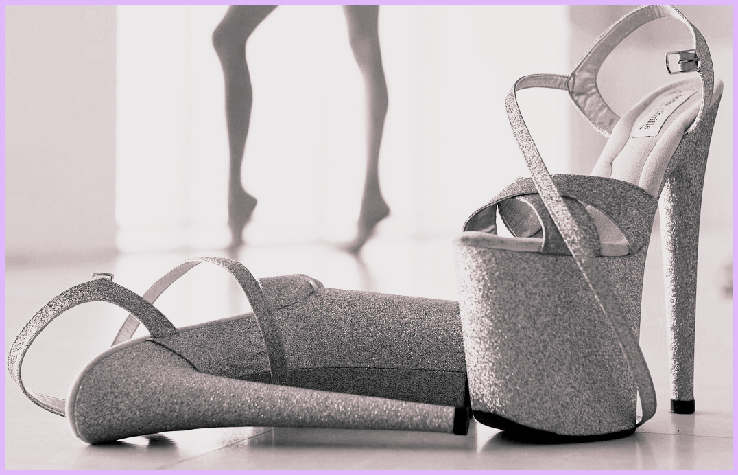 Pair of glitter platform heels for pole dance with dancer silhouette in background studio