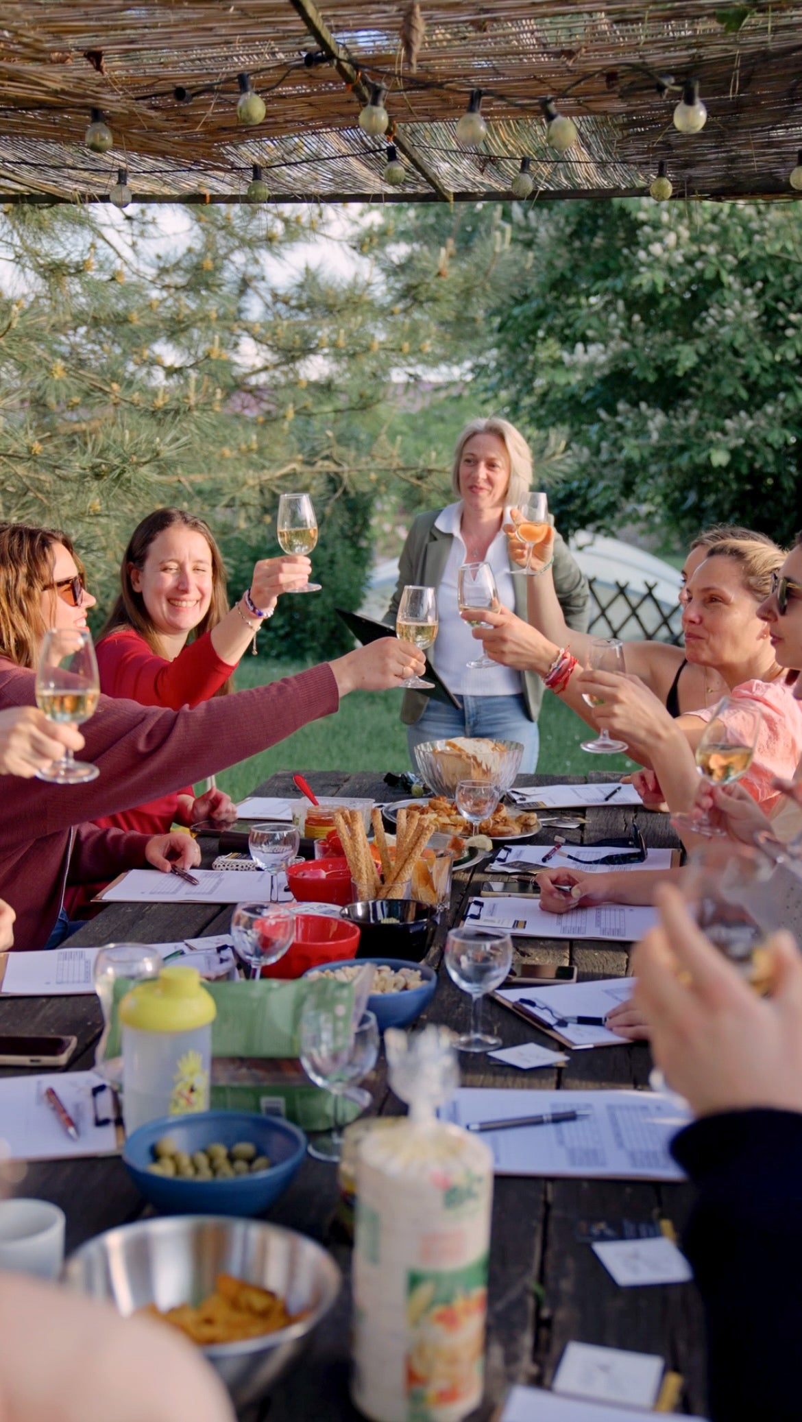 A group of girls cheering with champagne around a table full of food quiz papers