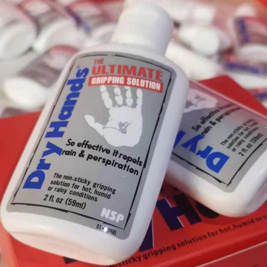 2 bottles of Dry hands liquid magnesium on top of each others on top of a red box, many bottles on the background that are blurry