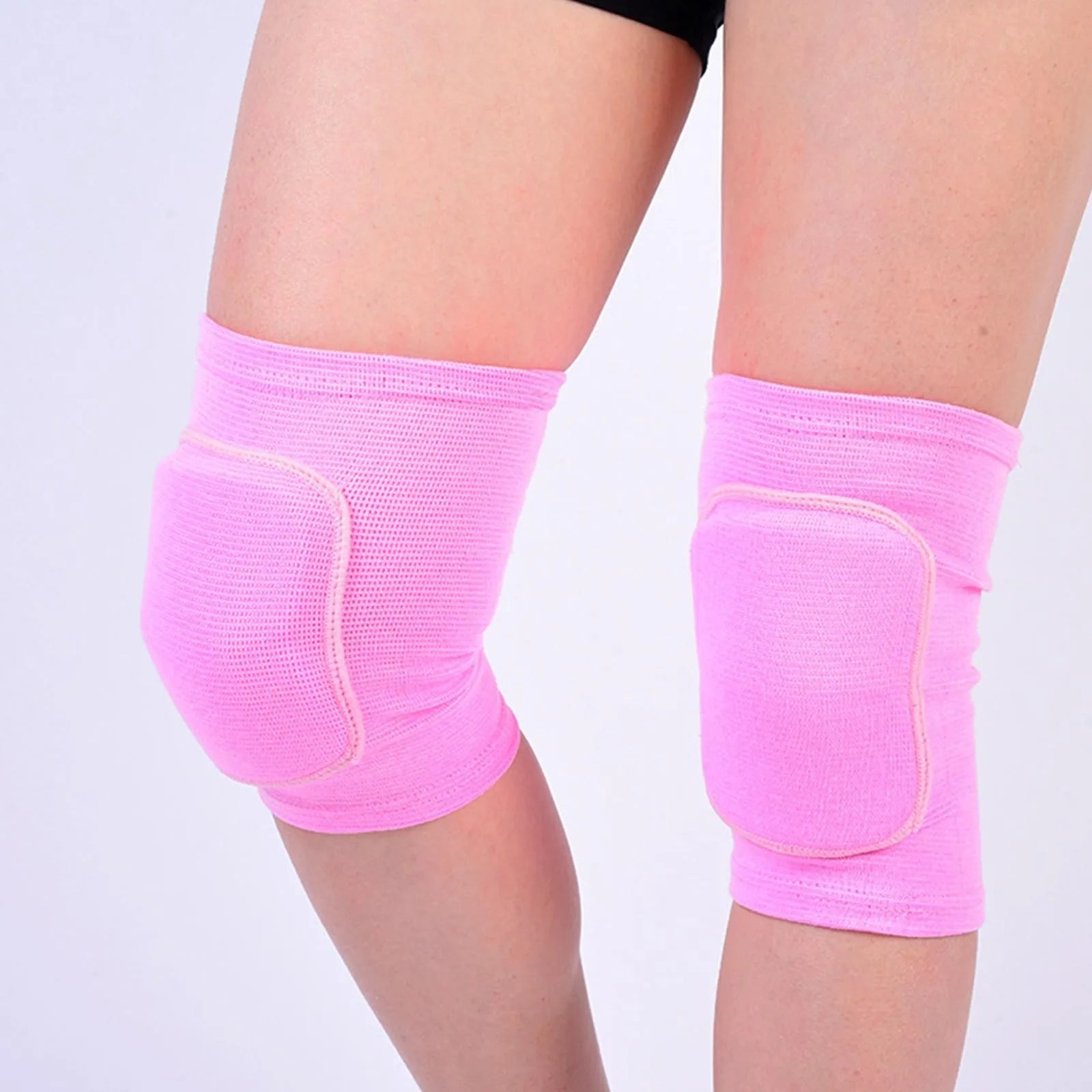 Light pink closed knee pads with padded protection over knees, worn on legs, elastic fabric.