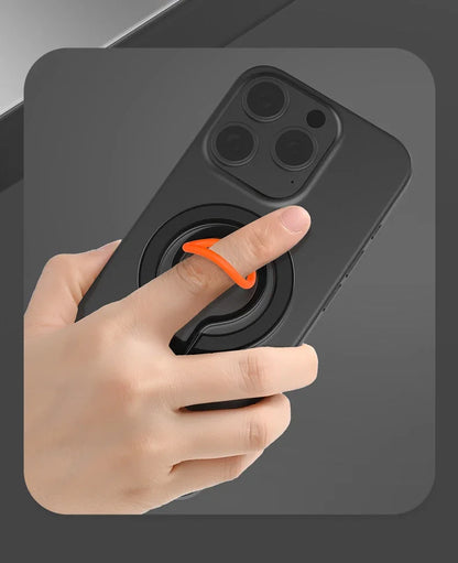 Hand holding a smartphone fitted with a black and orange magnetic ring holder, focusing on the ergonomic silicone ring grip.