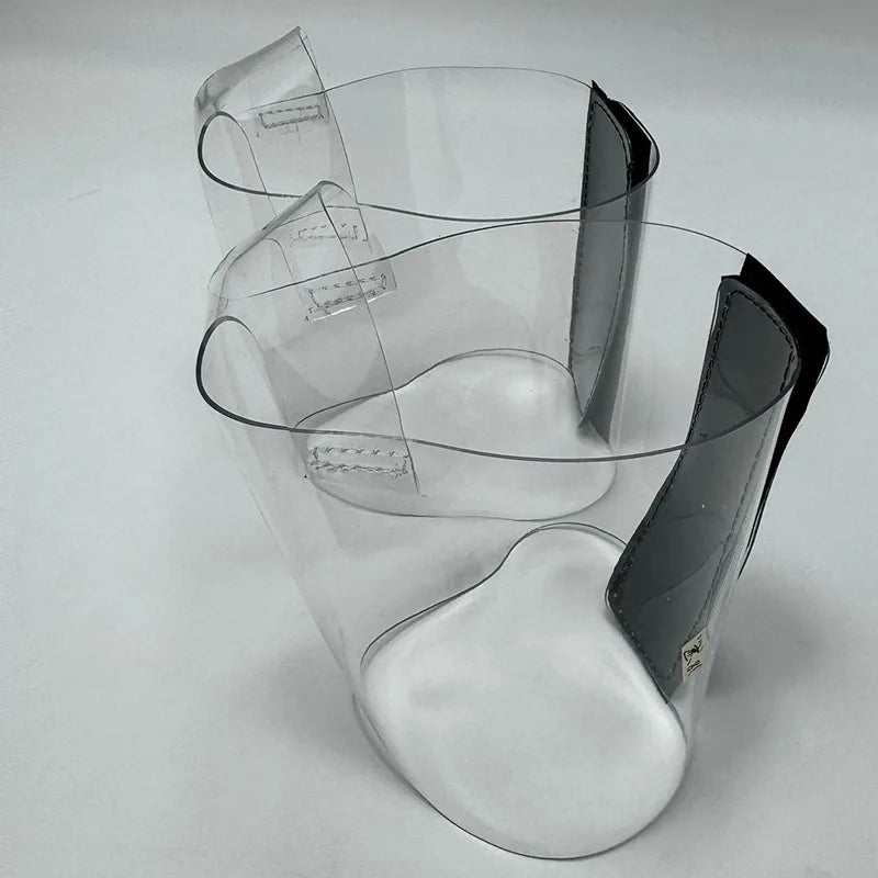 Pair of Transparent platform protectors with a black rear hook-and-loop closure heel shown from the left side
