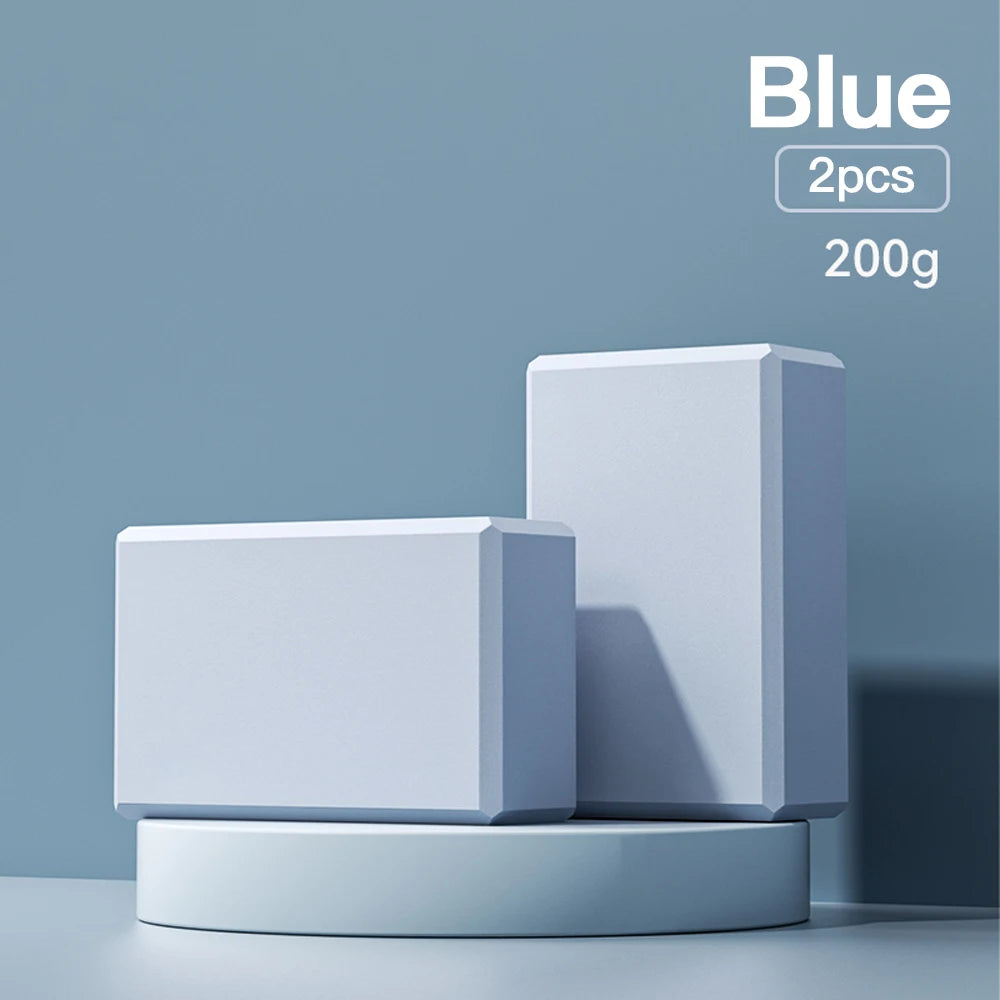Two blue high-density foam yoga blocks on a blue display stand, indicating 'Blue, 2pcs, 200g'.